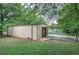 View of the metal sided garage with concrete drive and awning, surrounded by trees and green grass at 200 Rogers Rd, Kingston, GA 30145
