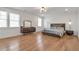 Spacious bedroom with hardwood floors, a dresser, and a modern pendant lamp at 4505 Caroline Walk, Dunwoody, GA 30338