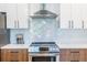 Close up of a kitchen range with stainless steel appliances and a stylish backsplash at 112 Rogers St # 208, Atlanta, GA 30317