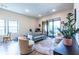 Cozy living room with natural light, hardwood floors, and a view of the balcony with outdoor seating at 112 Rogers St # 208, Atlanta, GA 30317