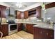 Modern kitchen with stainless steel appliances, tile backsplash, dark cabinetry, and wood-look flooring at 1350 Overlook Se Cv, Smyrna, GA 30080