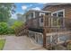 Rear view of the home featuring a wooden deck, sunroom, and partially exposed basement at 4457 Huntshire Dr, Stone Mountain, GA 30083