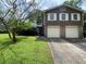 Charming split-level home with a two-car garage and well-maintained front lawn at 4457 Huntshire Dr, Stone Mountain, GA 30083