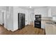 Open kitchen featuring modern black appliances, wood-look flooring, and bright white cabinets at 4457 Huntshire Dr, Stone Mountain, GA 30083