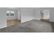 Open-concept living room featuring new gray carpet, light gray paint, and an abundance of natural light at 4457 Huntshire Dr, Stone Mountain, GA 30083