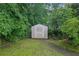 Backyard shed surrounded by lush landscaping and mature trees at 4457 Huntshire Dr, Stone Mountain, GA 30083