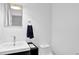 Bathroom featuring a stylish mirror, modern sink, and a toilet, all complemented by fresh, white walls at 11 Ardmore Nw Sq, Atlanta, GA 30309