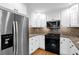 Stainless steel appliances, white cabinets, granite countertops and hardwood floors in this modern kitchen at 11 Ardmore Nw Sq, Atlanta, GA 30309