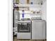 Efficient laundry room featuring modern washer, dryer, water heater, and ample shelving at 11 Ardmore Nw Sq, Atlanta, GA 30309