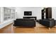 Contemporary living room with hardwood floors, stylish black seating, and a bright bay window at 11 Ardmore Nw Sq, Atlanta, GA 30309