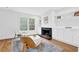 Cozy living room with hardwood floors, a fireplace, built-in shelves, and modern chairs at 11 Ardmore Nw Sq, Atlanta, GA 30309