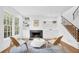 Cozy living room features a fireplace, built-in shelves, and modern chairs with a view of the staircase at 11 Ardmore Nw Sq, Atlanta, GA 30309