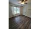 Bright bedroom features hardwood floors, a ceiling fan, and a large window at 129 Carolyn Path, Rockmart, GA 30153