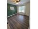 Cozy bedroom featuring hardwood floors, a ceiling fan, and a large window at 129 Carolyn Path, Rockmart, GA 30153