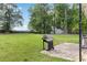 View of a large, grassy backyard with a patio and a grill, perfect for outdoor enjoyment at 2469 Silver King Dr, Grayson, GA 30017