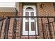 Close up of the lovely, white front door framed by brick with black railing on the stoop at 2469 Silver King Dr, Grayson, GA 30017