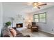 Cozy living room featuring a stone fireplace, ceiling fan, with comfortable furniture and natural light at 2469 Silver King Dr, Grayson, GA 30017