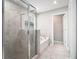 Bright bathroom featuring a glass shower, tub, and neutral tile flooring at 2769 Morgan Spring Trl, Buford, GA 30519