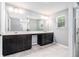 Bathroom showcasing double sinks, dark wood cabinets, and a large mirror at 2769 Morgan Spring Trl, Buford, GA 30519