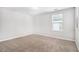 Simple empty bedroom with neutral walls and carpet, and natural light at 2769 Morgan Spring Trl, Buford, GA 30519