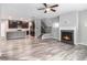 Open-concept living room featuring a fireplace, ceiling fan, and an adjacent kitchen with stainless appliances at 2769 Morgan Spring Trl, Buford, GA 30519