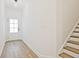 Inviting entryway with wood floors, staircase, white walls, and natural light from glass door at 4663 Larkfield Way, Powder Springs, GA 30127