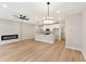 Modern living room and kitchen features light hardwood floors and a cozy fireplace at 4663 Larkfield Way, Powder Springs, GA 30127