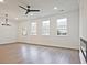 Spacious living room with wood floors, ample windows, neutral paint, and modern ceiling fan at 4663 Larkfield Way, Powder Springs, GA 30127