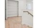 Hallway with a convenient closet space featuring wire rack shelving and hardwood floor at 4663 Larkfield Way, Powder Springs, GA 30127