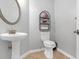 Powder room features a pedestal sink, toilet, and decorative shelving at 5645 Carrington Pl, Cumming, GA 30040