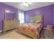 Comfortable bedroom painted in a vibrant purple at 5645 Carrington Pl, Cumming, GA 30040