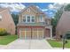 Charming two-story home featuring a brick and tan facade, a two-car garage, and a well-manicured lawn at 5645 Carrington Pl, Cumming, GA 30040