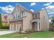 Charming two-story home with brick accents, well-manicured lawn, and a two-car garage at 5645 Carrington Pl, Cumming, GA 30040