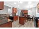 Well-equipped kitchen with stainless steel appliances, dark countertops, and wood cabinets at 5645 Carrington Pl, Cumming, GA 30040