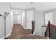 Bright upstairs hallway with hardwood floors, neutral walls, and stylish lighting fixtures at 5645 Carrington Pl, Cumming, GA 30040