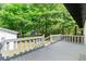 A grey wooden deck with a railing overlooks the lush, green backyard at 2125 Lynn Sw Dr, Marietta, GA 30060