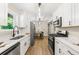 Modern kitchen features new stainless steel appliances, white cabinets, and stylish lighting fixtures above the countertop at 2125 Lynn Sw Dr, Marietta, GA 30060