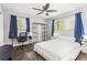 Bedroom with a bed, side tables, desk with rolling chair, and dark-stained wood-look flooring at 271 Leafwood Ln, Riverdale, GA 30274