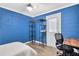 Blue bedroom with textured walls, wood-look flooring, and door leading outside at 271 Leafwood Ln, Riverdale, GA 30274
