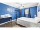 Bedroom with dark blue painted walls, bed, desk with rolling chair, and dark-stained wood-look flooring at 271 Leafwood Ln, Riverdale, GA 30274