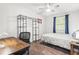Well-lit bedroom with hardwood floors, ceiling fan, desk area and a metal shelving unit at 271 Leafwood Ln, Riverdale, GA 30274