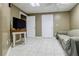 The basement is spacious with two doors, tile flooring, TV and comfortable sofa at 1018 Jubilee Way, Powder Springs, GA 30127