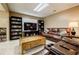 Finished basement with a large, comfortable brown leather couch, entertainment center, and a large wooden coffee table at 1018 Jubilee Way, Powder Springs, GA 30127