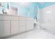 Coastal-themed bathroom with blue walls, a vanity with ample storage, and a shower-tub combination at 1018 Jubilee Way, Powder Springs, GA 30127