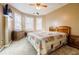 Cozy bedroom with a colorful patchwork quilt, three windows for lots of light, and wood furniture at 1018 Jubilee Way, Powder Springs, GA 30127