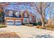 Elegant two-story brick home with a two-car garage and beautifully landscaped front yard on a sunny day at 1018 Jubilee Way, Powder Springs, GA 30127