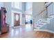 Inviting foyer with hardwood floors, a staircase, and a decorative front door at 1018 Jubilee Way, Powder Springs, GA 30127