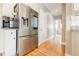 Bright kitchen with stainless steel refrigerator and hardwood floors leading to hallway at 1018 Jubilee Way, Powder Springs, GA 30127