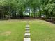 Large backyard with brick-lined flower beds and stepping stone path through the lawn at 2616 Boddie Pl, Duluth, GA 30097
