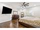 Bright bedroom featuring a ceiling fan, wood floors, a large window, and a dresser with mirror at 2616 Boddie Pl, Duluth, GA 30097